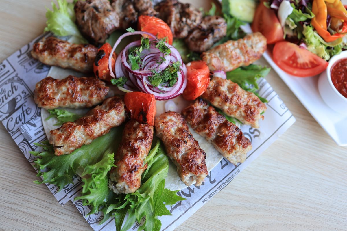 Gegrillte Fleischspieße mit frischem Salat und Dip